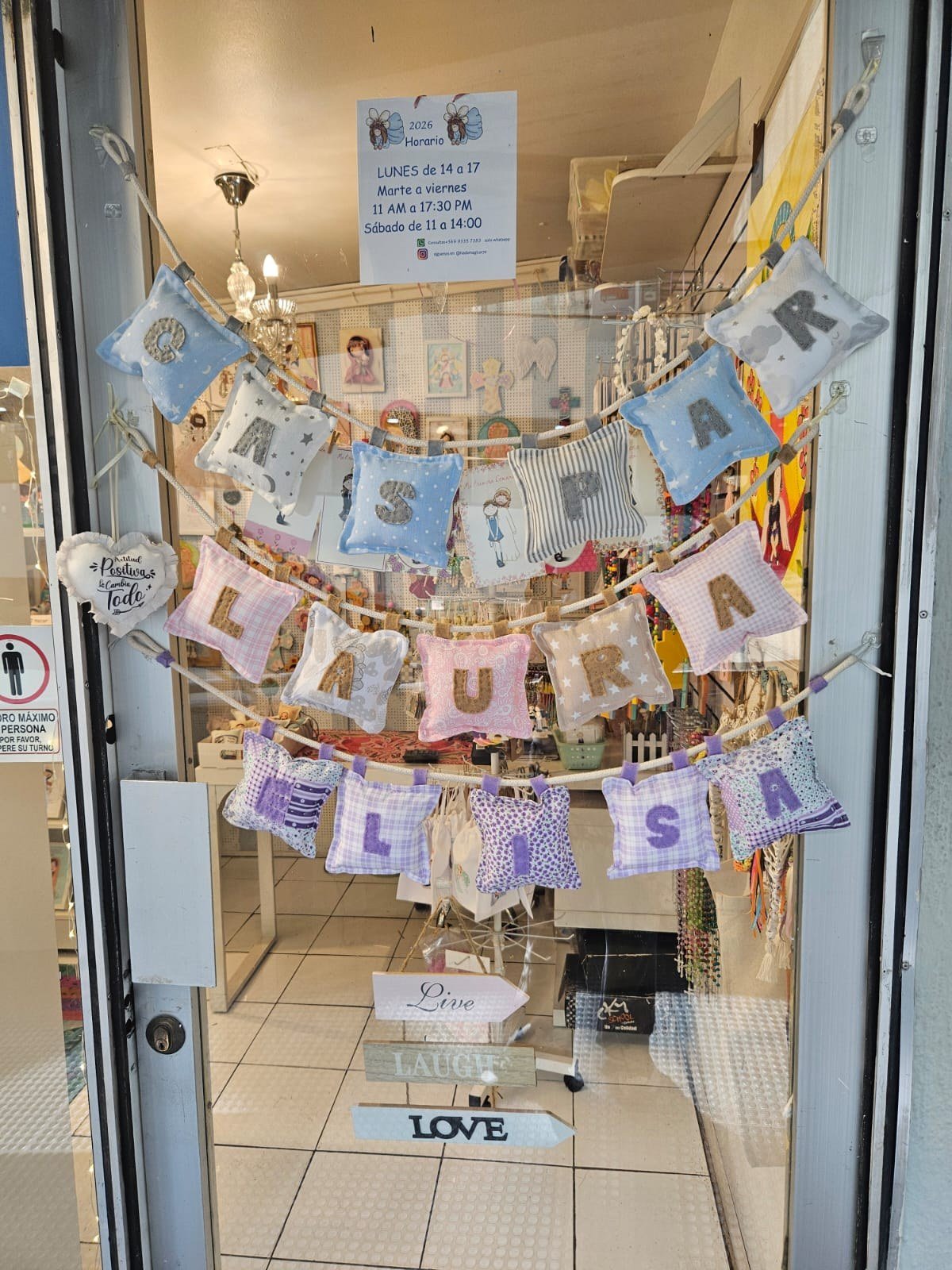 Cojines con nombres personalizados colgados en la puerta del local de Hada Mágica
